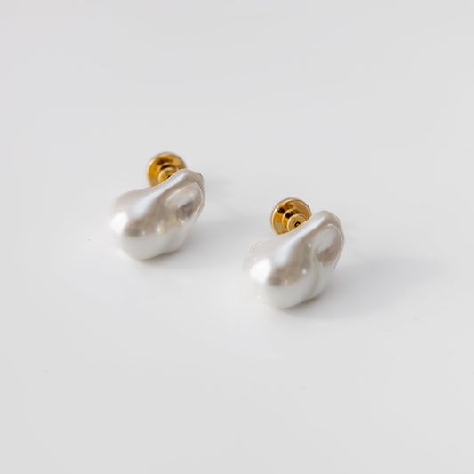 Pair of pearl earrings with gold accents on a light gray background