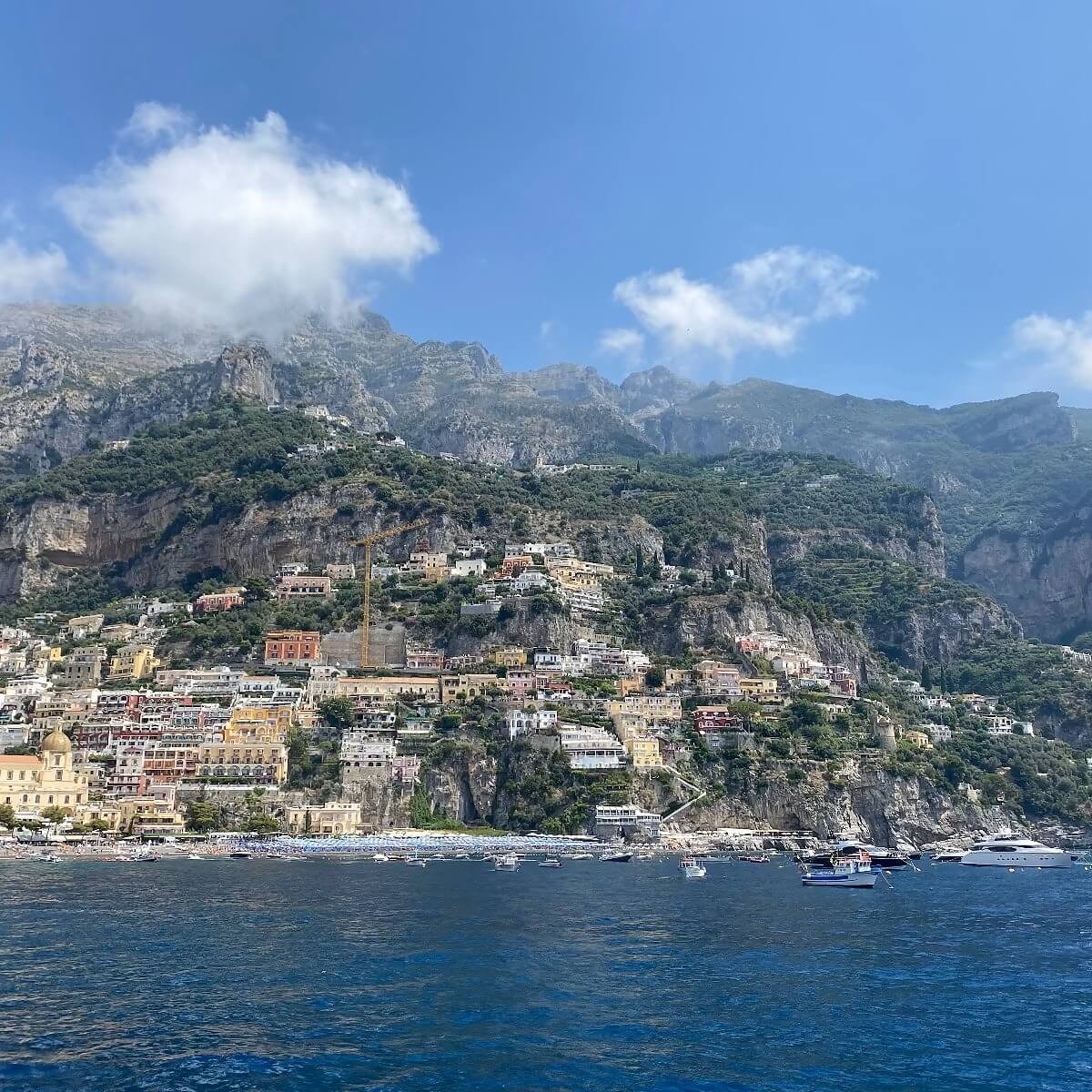 Classic European brand aesthetic Hilly coastal town with buildings on a mountain side, overlooking the sea.