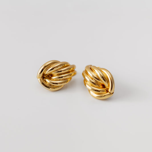 Pair of gold earrings on a light gray background